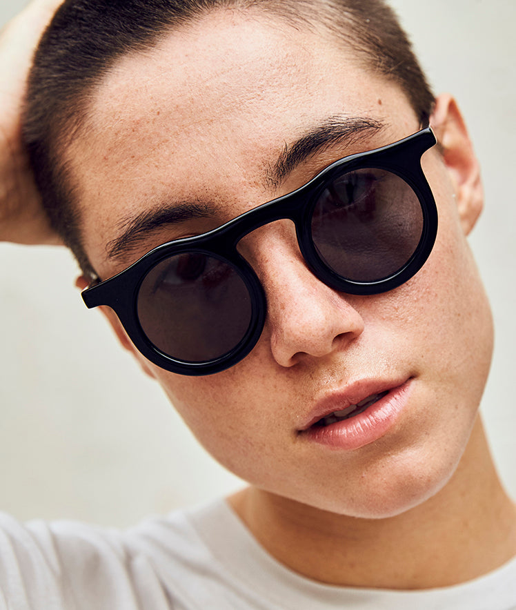 Lind-midnight-black-small-round-black-sunglasses-on-model